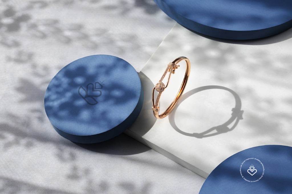 Swaadha rose gold diamond bangle on branded blue box — premium jewellery product photography